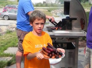 Sam helps bring in some brats and hot dogs for sampling.